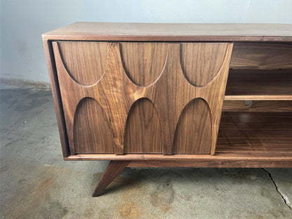 The Bagel walnut credenza styled as the centerpiece of a mid-century modern living room offering versatile storage and classic design.