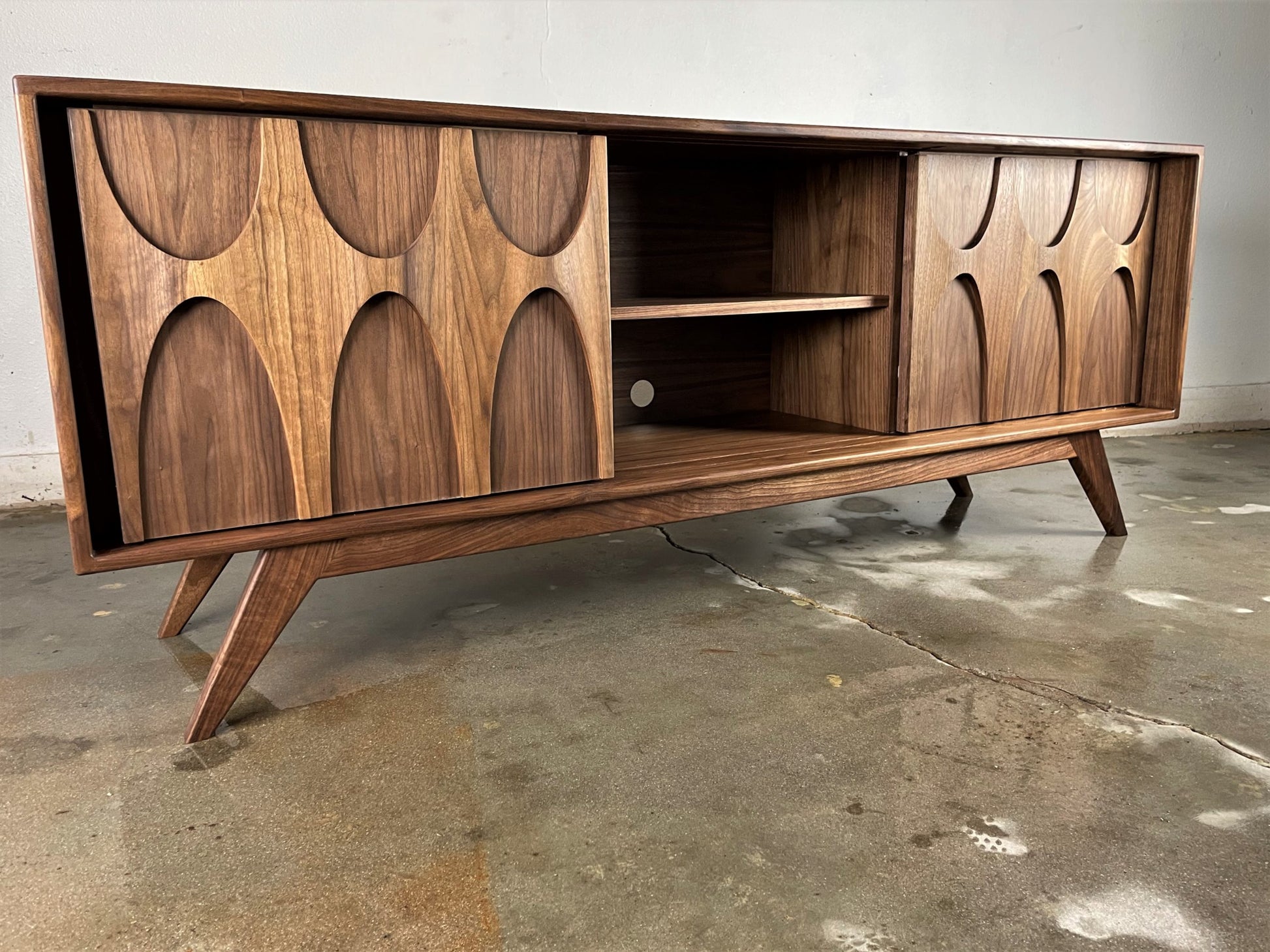 Front view of the Bagel credenza, a handcrafted walnut piece featuring a classically mid-century modern design and sliding doors