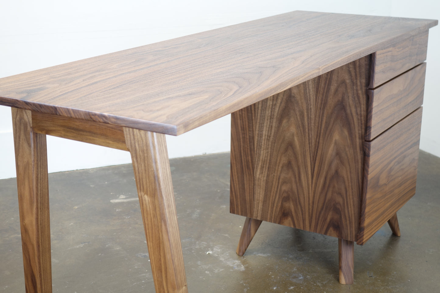 Close-up of the natural walnut wood grain on the Cosmo desk, highlighting its hand-applied natural oil and wax finish