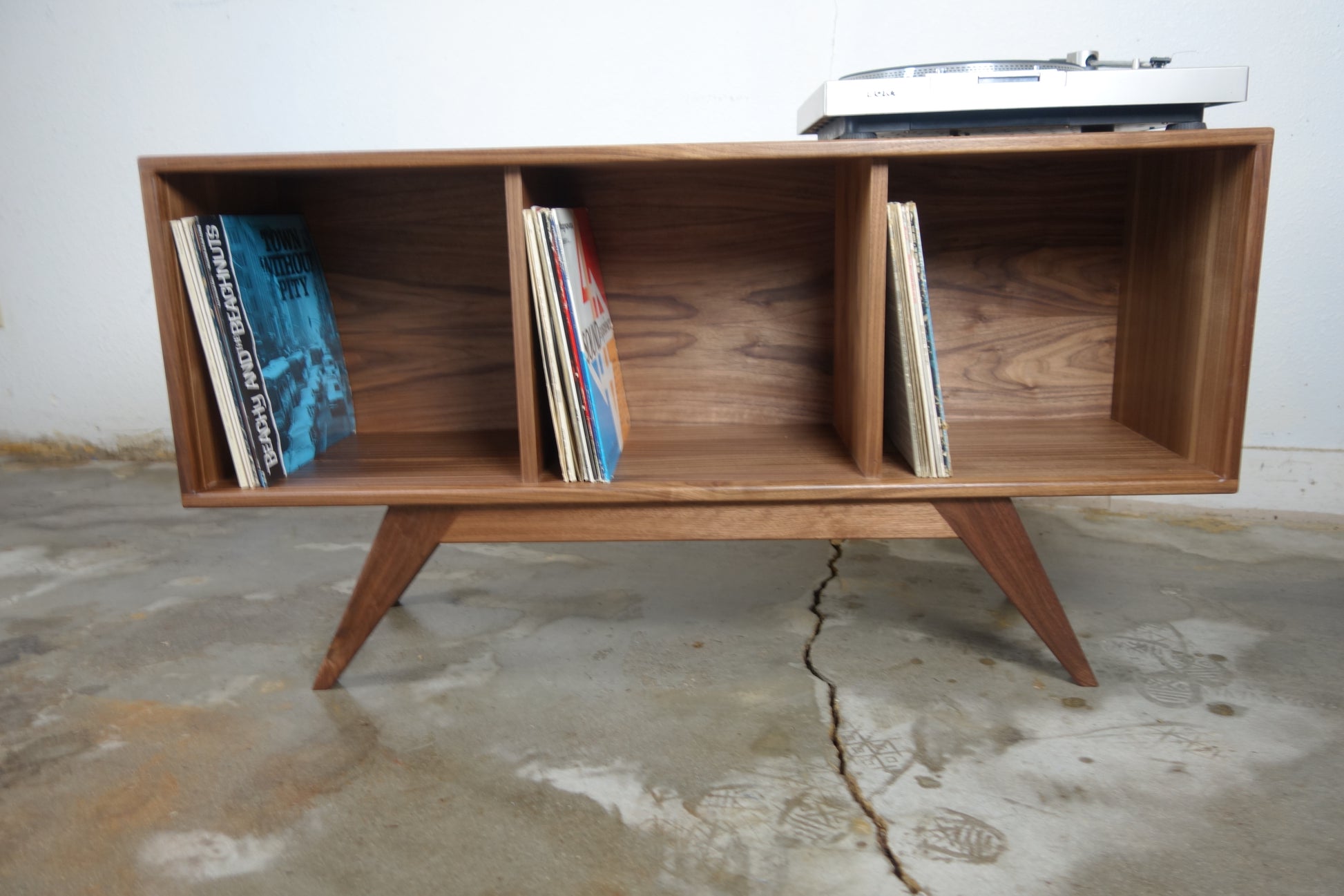 Front view of the Dabble console, handcrafted in walnut with a compact mid-century modern design ideal for record collectors