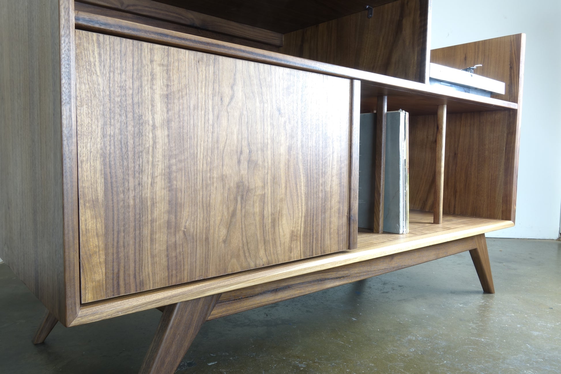 Detailed view of the hinged door on the Electric Koolaide credenza, complete with an adjustable shelf for customizable storage