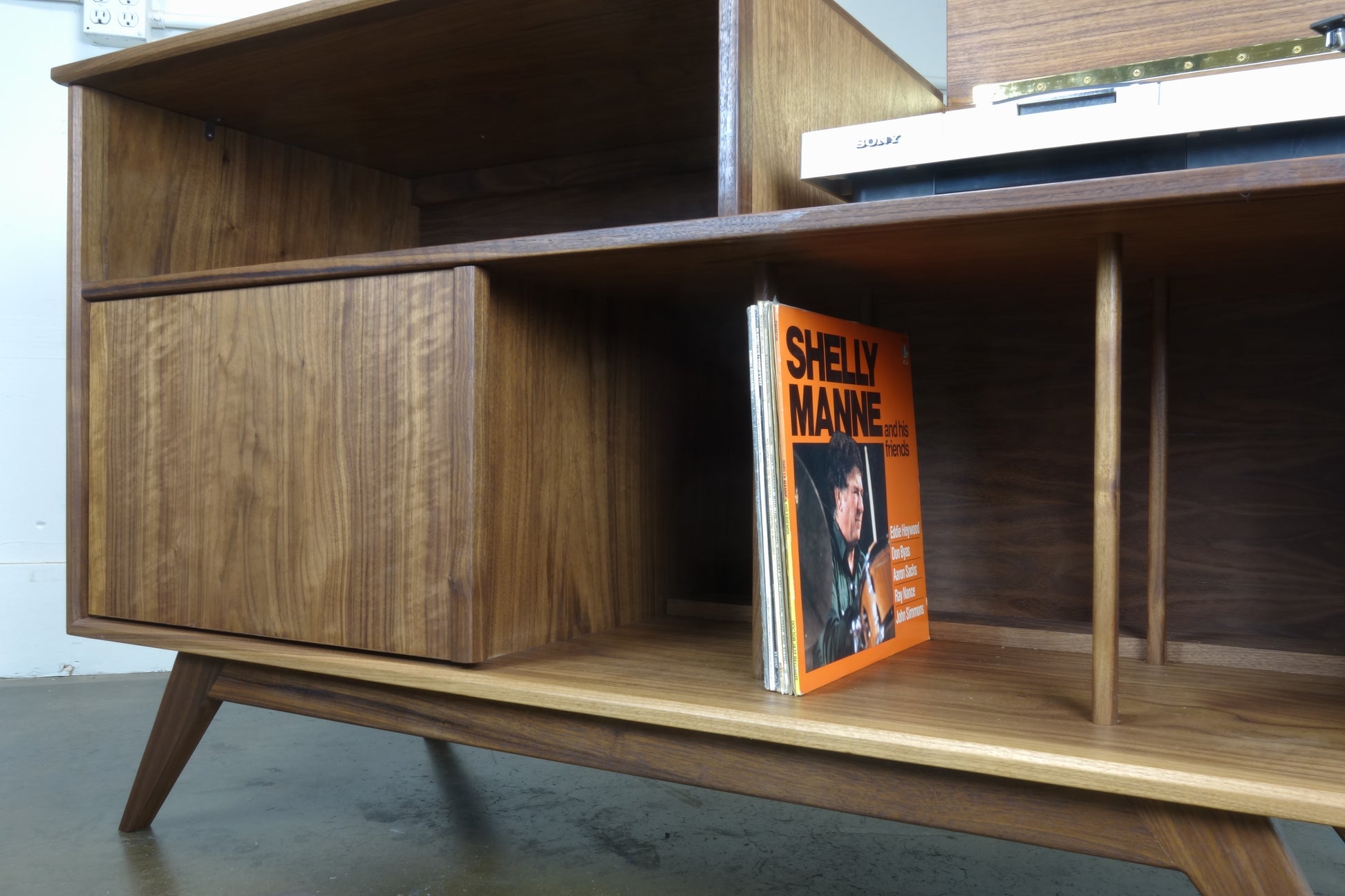 Front view of the Electric Koolaide credenza, handcrafted in walnut with a mid-century modern design and record storage dividers