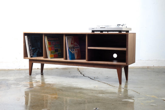 Front view of the Jelly console, hand-built in walnut with mid-century modern style, featuring record storage and an adjustable shelf