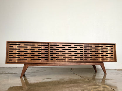 Walnut media console with clean lines and handcrafted mid century modern styling.