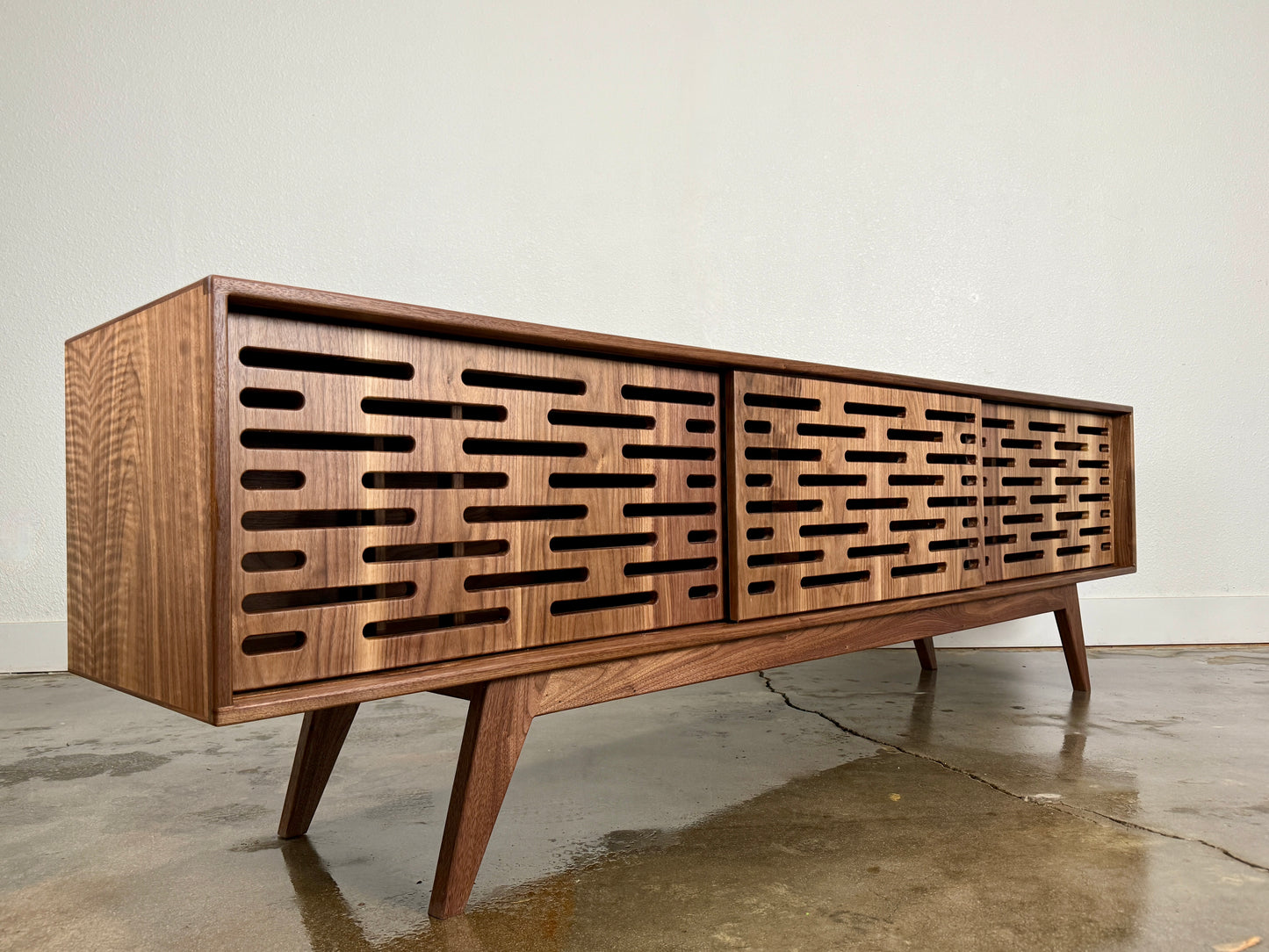 Walnut TV console handcrafted in a mid century modern design.