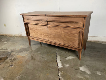 Front view of the Nanoo credenza, handcrafted in walnut with two sliding doors, a flip top for a record player, and record storage dividers