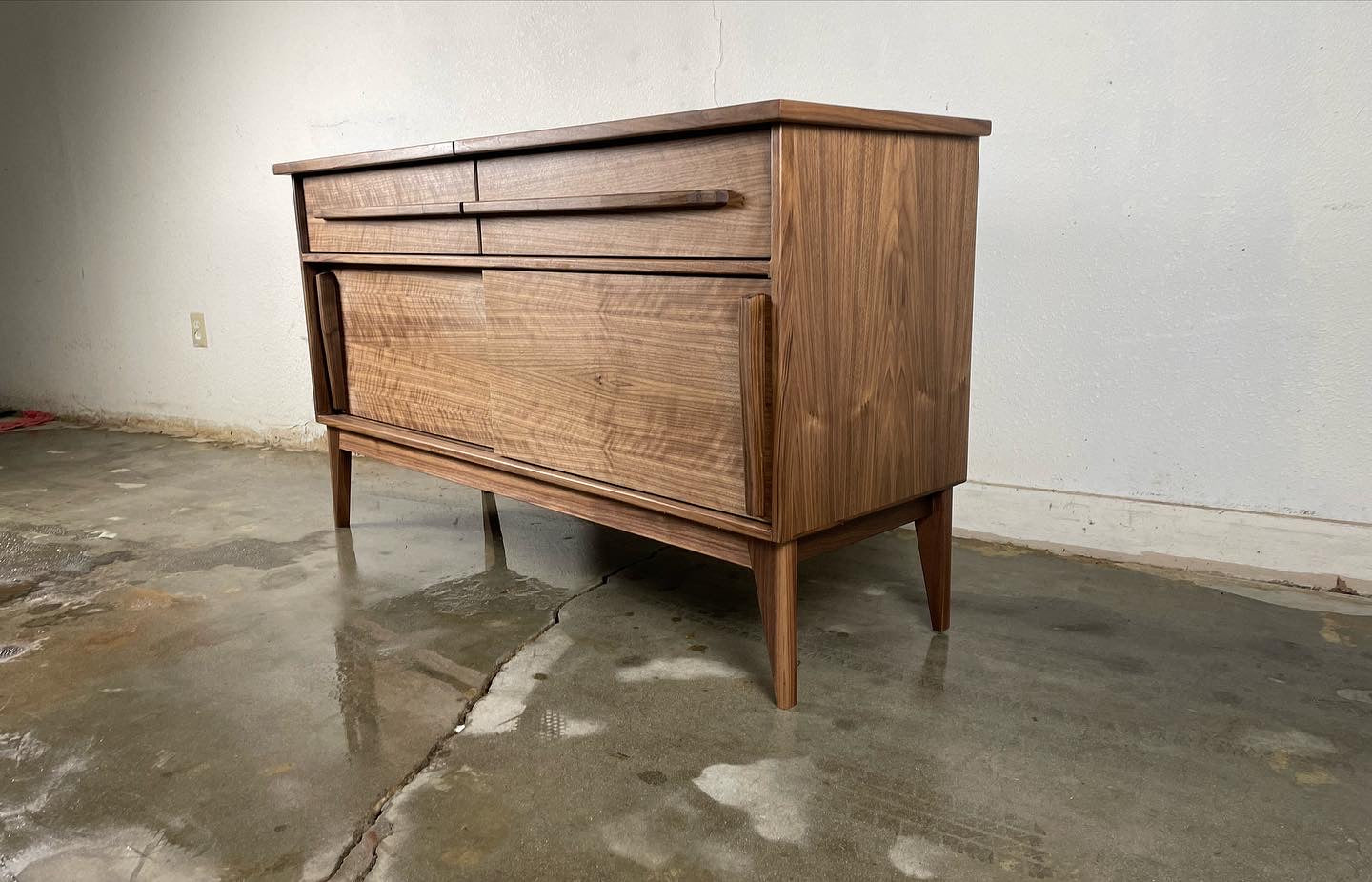 Detailed view of the natural walnut wood grain on the Nanoo credenza, finished with hand-applied oil and wax for a smooth look