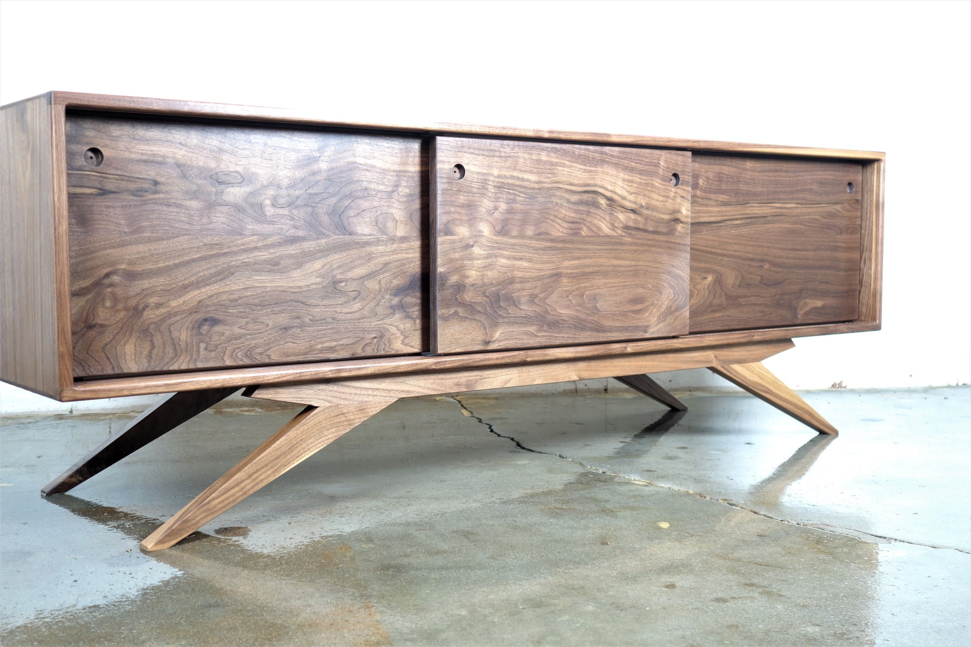 Front view of the Sonic credenza, hand-built from solid walnut with three sliding wood doors and a mid-century modern design