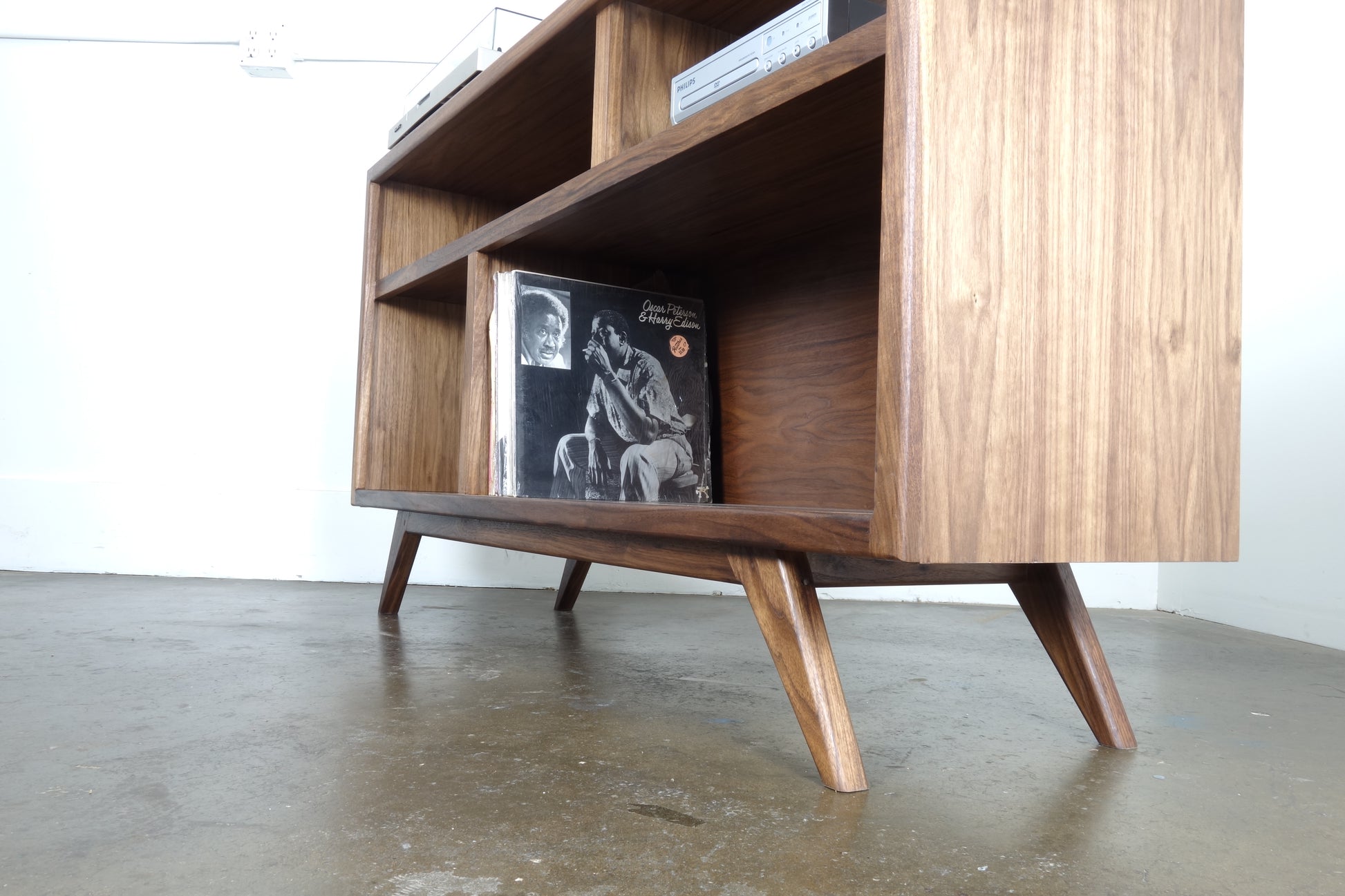 Record storage console made from walnut, measuring 55 inches by 16 inches by 30 inches, perfect for storing and playing records.